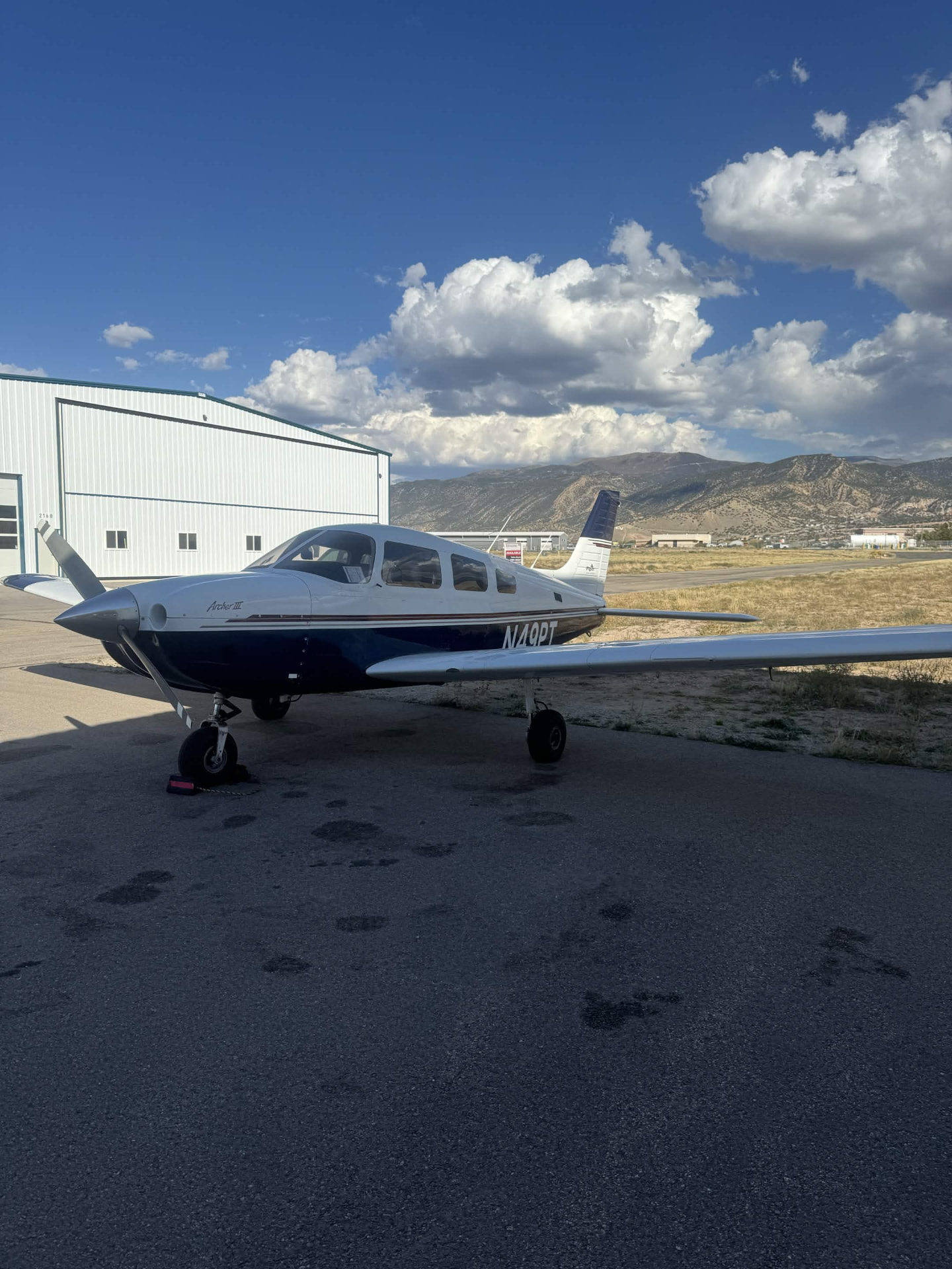 Piper Archer N49PT training aircraft parked beside a hangar at Cedar City Regional Airport, Utah